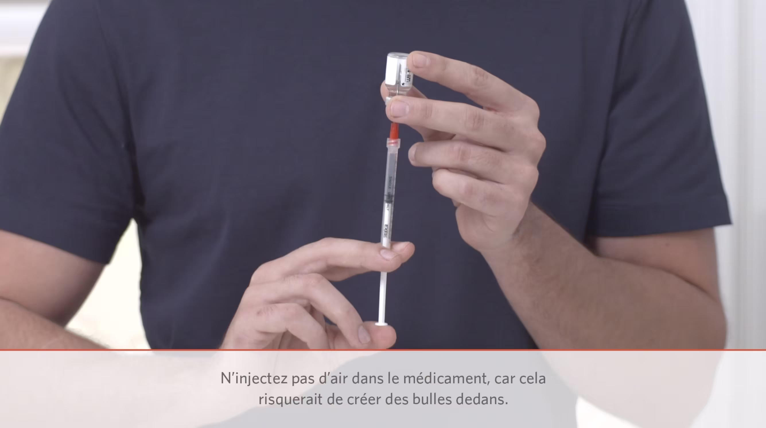 Close-up of a person preparing an injection by drawing liquid into a syringe and removing air bubbles.